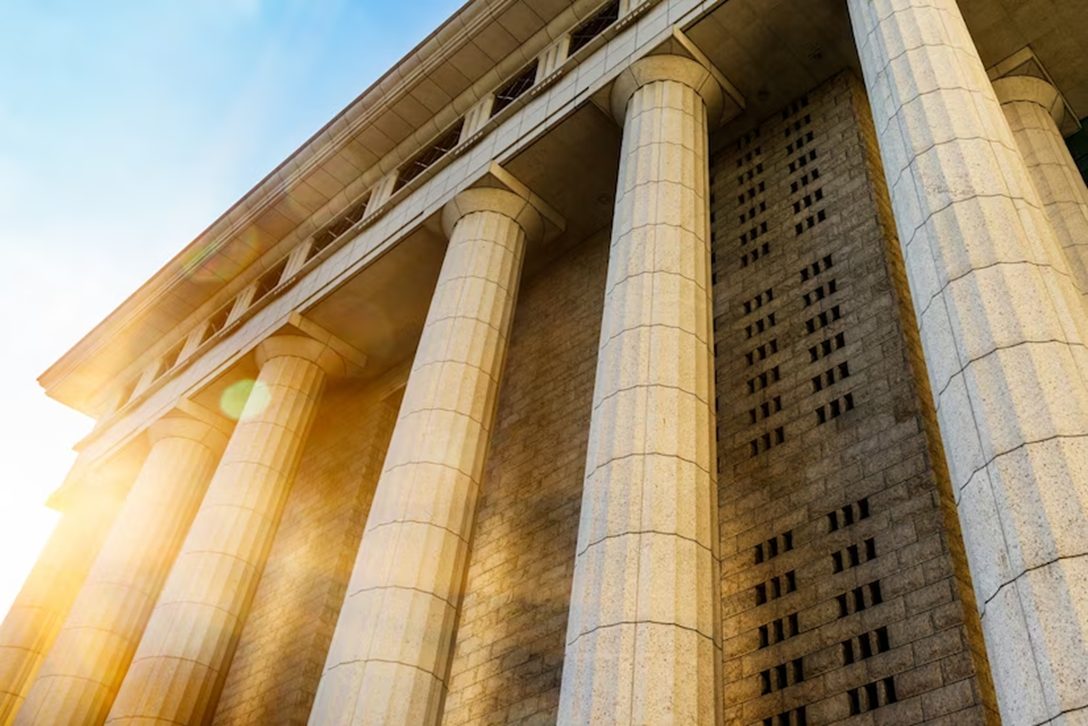 Classical courthouse columns lit by sunlight